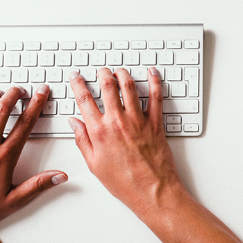 hands typing on a computer keyboard