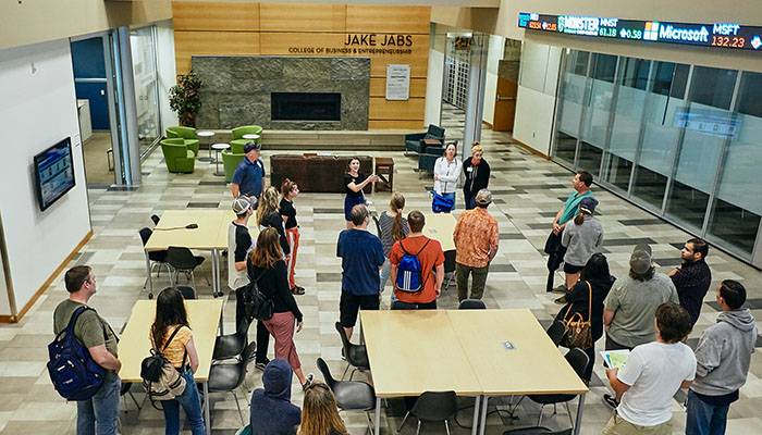 MSU student giving a tour of Jabs Hall to visiting families. They are standing in the building Forum