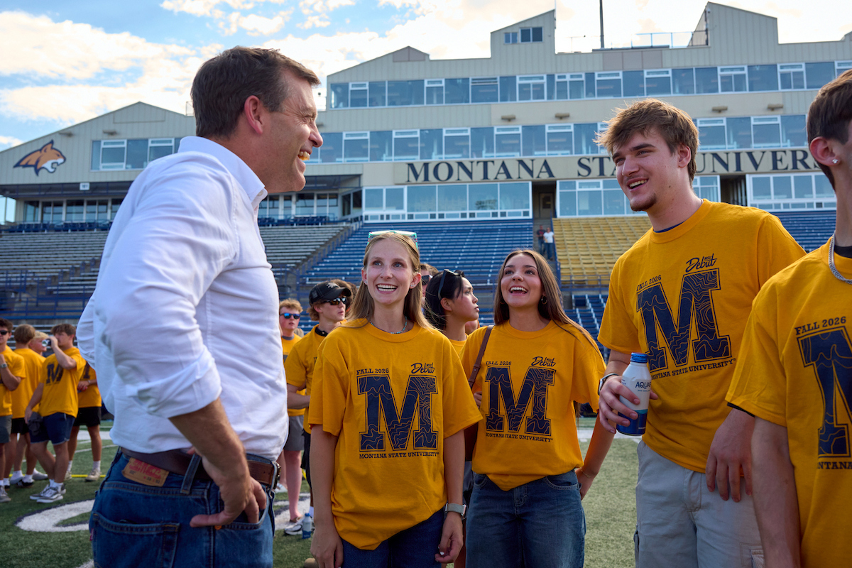 President Tessman laughing with students inside Bobcat Stadium