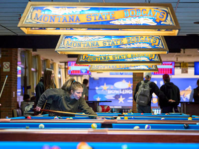 Montana State University student employee teaching billiards in the Strand Union Rec Center