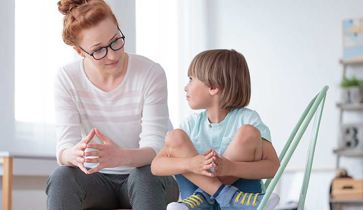 Boy sitting cross-legged with counselor