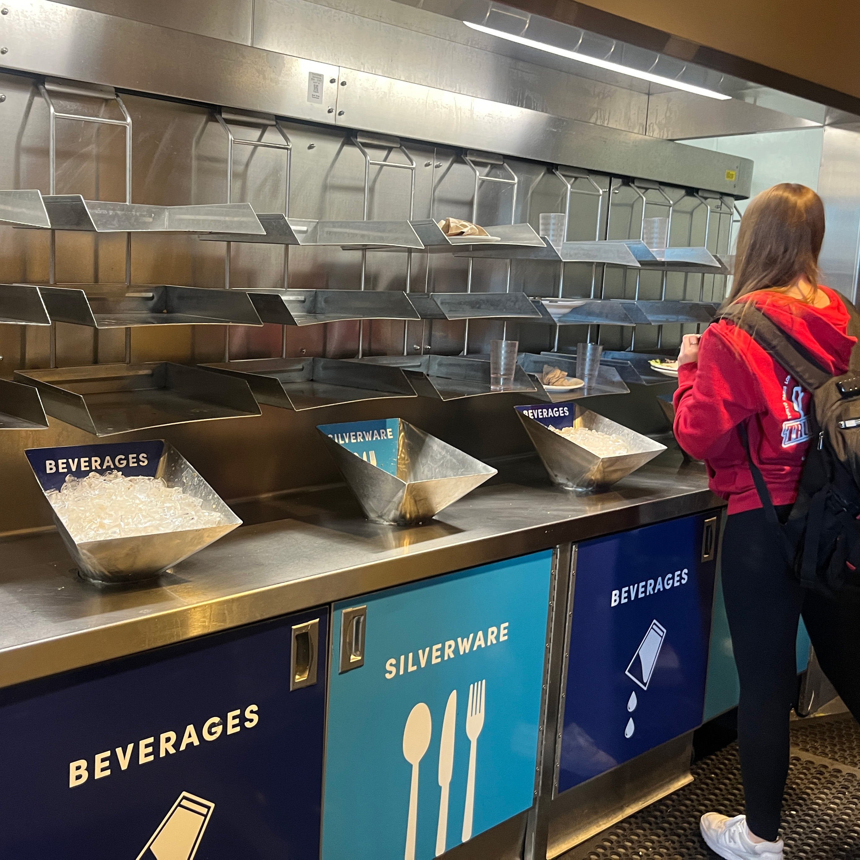 student placing dishes in the dish return carousel