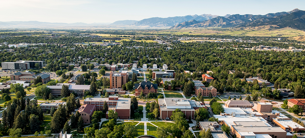 Aerial shot of campus with blue sky and mountains in the background