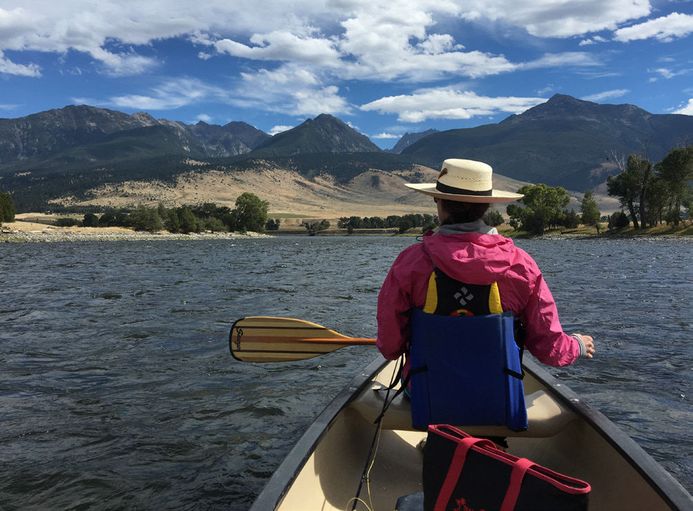 A woman paddling on a lake.