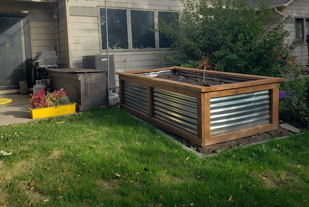 A neat lawn with a large, deep rectangular garden box sitting on top.