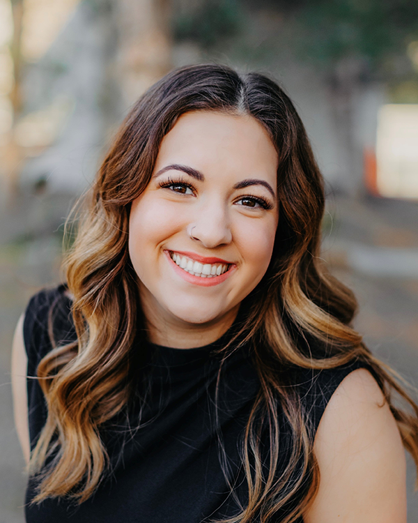 A person with long dark hair wearing a black shirt