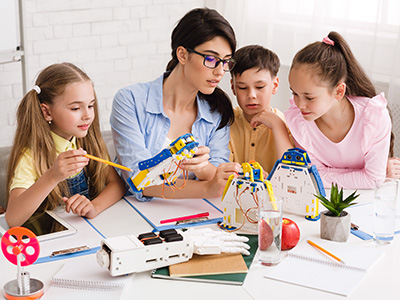 teacher working with students on a classroom project