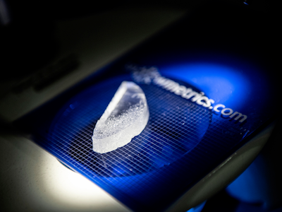 close-up of piece of ice on blue tray on microscope